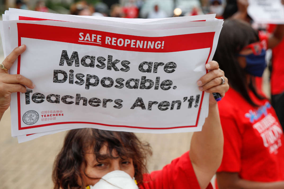 A woman holds a sign during the Occupy City Hall Protest and Car Caravan hosted by Chicago Teachers Union in Chicago, Illinois, on August 3, 2020.