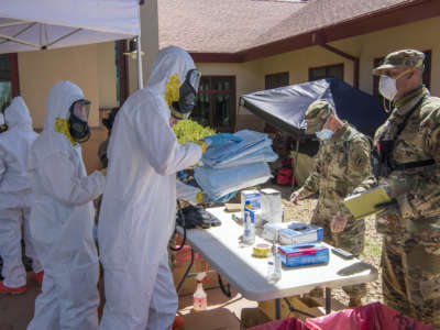 Colorado National Guard members of the Chemical, Biological, Radiological, Nuclear and high-yield (CBRNE) Enhanced Response Force Package (CERFP) team member, processes through the decontamination station after performing COVID-19 testing at a state veterans home in Aurora, Colorado, April 29, 2020.