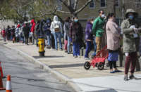 People line up for a food bank organized by Healthy Waltham in Waltham, Massachusetts, on April 11, 2020.