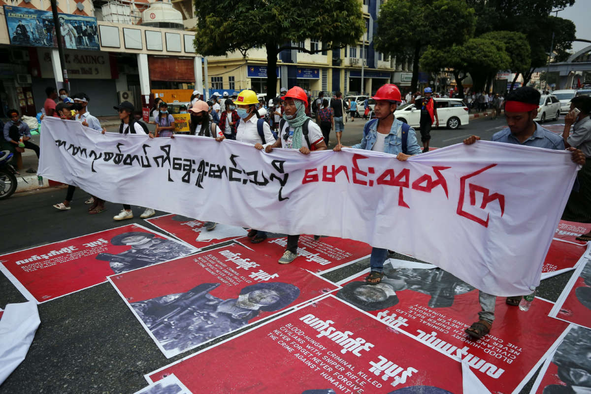 Myanmar protesters hold a huge poster as they march during a demonstration against the military coup near Sule Pagoda in central Yangon, Myanmar, on February 22, 2021.