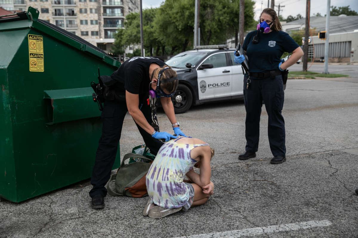 Medics with Austin-Travis County EMS check a woman with potential COVID-19 symptoms after she was found unconscious in a parking lot on August 3, 2020, in Austin, Texas. Austin's especially high unsheltered population is considered vulnerable to the pandemic.