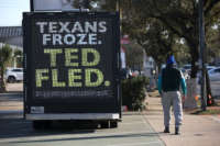 A pedestrian walks by a digital billboard truck with an image of Sen. Ted Cruz as it sits in a parking lot near Cruz's home on February 19, 2021, in Houston, Texas.