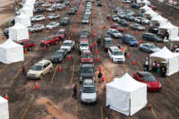 People drive their cars to medical tents at a mass COVID-19 vaccination event on January 30, 2021, in Denver, Colorado.
