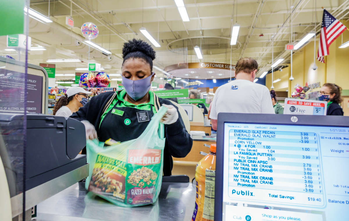 A cashier bags items at a Publix supermarket in Miami Beach, Florida, on May 27, 2020. In December 2020, Publix cosponsored a conference for legislators and corporate executives to discuss legal immunity from COVID-19 lawsuits.