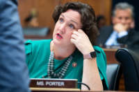 Katie Porter talks to someone at her desk