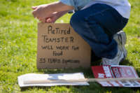 Jan Kacher of Deerfield, Michigan, adjusts a sign as he rallies on the West Front of the U.S. Capitol building with fellow Teamsters Union retirees who traveled from across the country to voice their opposition to deep cuts to their pension benefits on April 14, 2016, in Washington, D.C.