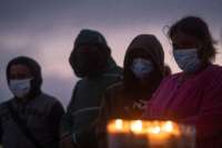 People mourn during a candlight vigil