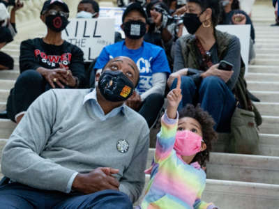 Dontaye Carter and daughter Kyleigh Carter look around the capitol building as demonstrators hold a sit-in inside of the capitol building in opposition of House Bill 531 on March 8, 2021, in Atlanta, Georgia.