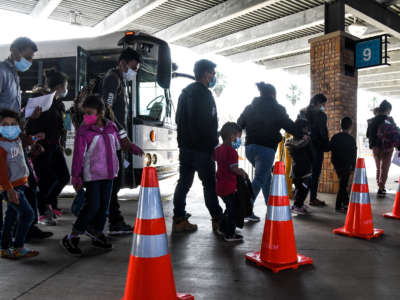 Migrants, mostly from Central America, are dropped off by the U.S. Customs and Border Protection at a bus station near the Gateway International Bridge, between the cities of Brownsville, Texas, and Matamoros, Mexico, on March 15, 2021.