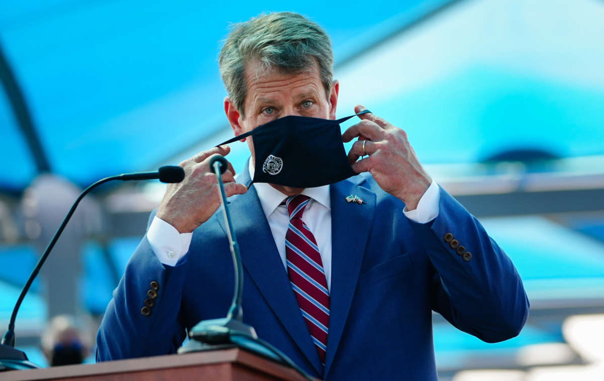 Georgia Gov. Brian Kemp puts on a mask after speaking at a press conference on August 10, 2020, in Atlanta, Georgia.