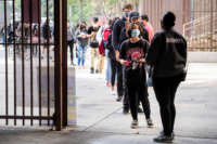 Students wait in a socially distanced line to enter Pasadena High School on April 20, 2021, during their first day of in-person learning since the pandemic closed schools over a year ago.