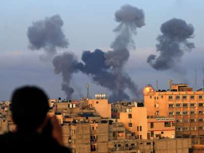 Smoke billows from homes bombed by Israeli forces