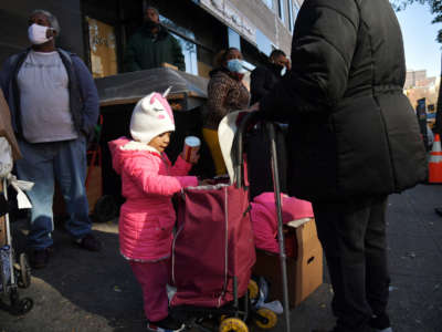 A view of a child as she stands in line with her family as Food Bank for New York City distributes turkeys and Thanksgiving fixings on November 16, 2020, in New York City.