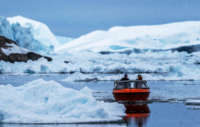 A boat navigates through icebergs near Ilulissat, Greenland, on May 5, 2021.