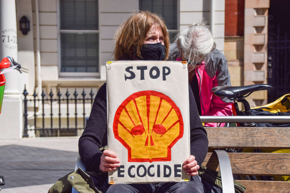 An Extinction Rebellion protester holds a 'Stop Ecocide' placard outside the Science Museum in London.