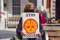 An Extinction Rebellion protester holds a 'Stop Ecocide' placard outside the Science Museum in London.