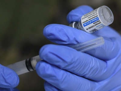 An Army nurse fills a syringe with the Johnson & Johnson vaccine at the FEMA-supported COVID-19 vaccination site at Valencia State College in Florida on April 25, 2021.