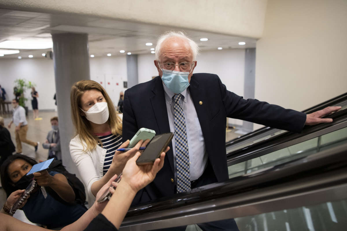 Sen. Bernie Sanders talks with reporters as he makes his way to the Senate floor for a vote in Washington on Wednesday, April 28, 2021.