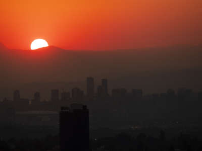 The sun sets on a city in the mountains