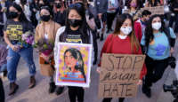 Demonstrators wearing face masks and holding signs take part in a rally "Love Our Communities: Build Collective Power" to raise awareness of anti-Asian violence, at the Japanese American National Museum in Little Tokyo in Los Angeles, California, on March 13, 2021.