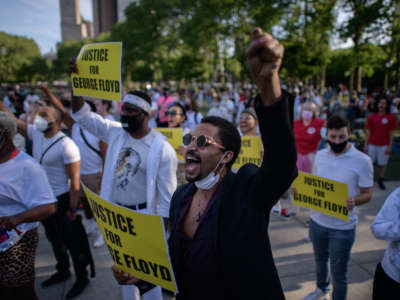 Black Lives Matter protesters hold placards and shout slogans during a march on the anniversary of the death of George Floyd, in Brooklyn, New York, on May 25, 2021.