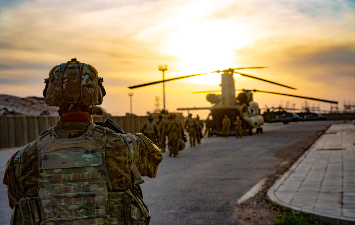 Soldiers board a CH-47 Chinook helicopter as they depart from al-Qaim base, Iraq, on March 9, 2020.