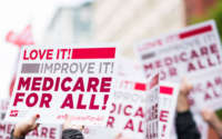 Members of National Nurses United union members wave "Medicare for All" signs during a rally in front of the Pharmaceutical Research and Manufacturers of America in Washington, D.C, calling for "Medicare for All" on April 29, 2019.