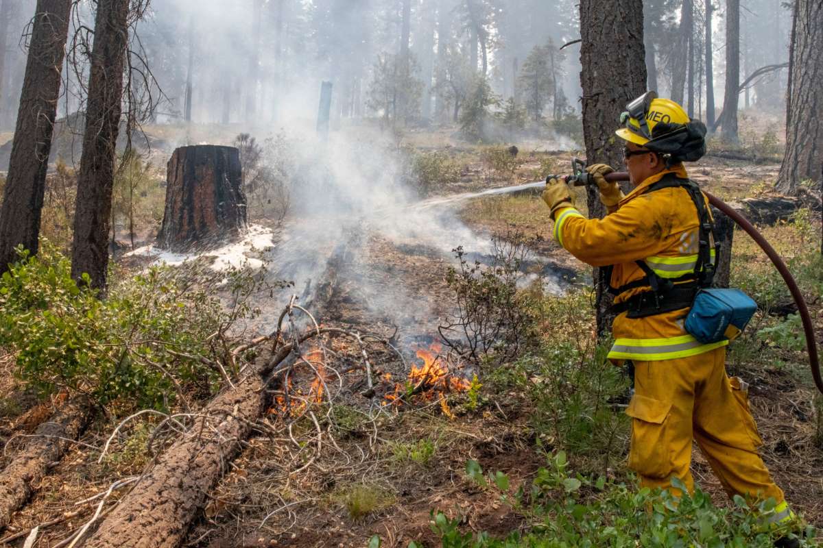 A firefighter out of California puts out hot spots on the Bootleg Fire north of Bly, Oregon, on July 17, 2021.