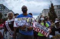 People hold placards with an image of the late Rep. John Lewis during a rally in support of voting rights, at Black Lives Matter Plaza in Washington, D.C., on July 17, 2021.