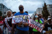 People hold placards with an image of the late Rep. John Lewis during a rally in support of voting rights, at Black Lives Matter Plaza in Washington, D.C., on July 17, 2021.