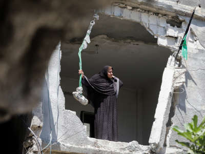 A woman looks through a massive hole where her wall used to be