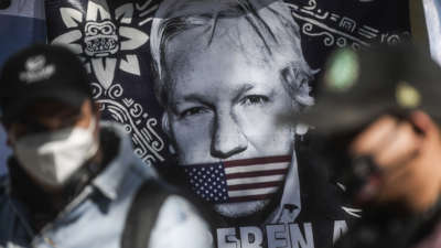 A painting of Julian Assange being gagged by the u.s. flag
