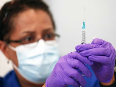 Pharmacist LaChandra McGowan prepares a dose of the Pfizer COVID-19 vaccine at a clinic operated by DePaul Community Health Center on August 12, 2021 in New Orleans, Louisiana.
