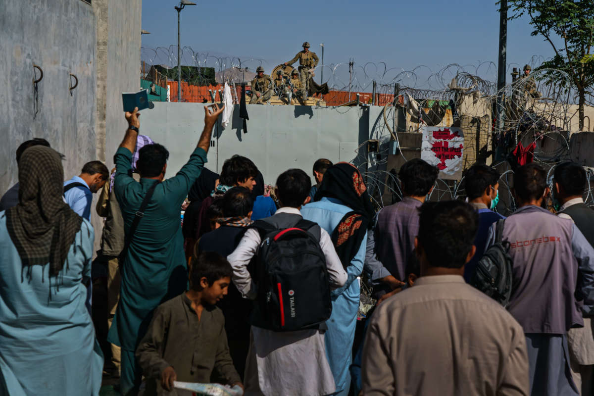 Afghans try to ask U.S. soldiers to be let into the East Gate of the airport in Kabul, Afghanistan, on August 25, 2021.