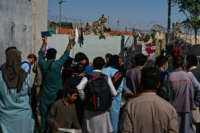 Afghans try to ask U.S. soldiers to be let into the East Gate of the airport in Kabul, Afghanistan, on August 25, 2021.