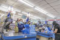 Cashiers work at El Presidente Supermarket in Florida, Miami Beach, on April 17, 2021.