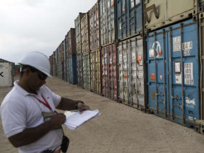A contractor with the Fluor Corporation takes inventory of containers delivered from U.S. bases that have closed or been turned over to Afghan security forces, on May 4, 2013, at FOB Shank, Afghanistan. The Texas-based defense contractor and construction firm received contracts of at least $85 million this year for work in Afghanistan.