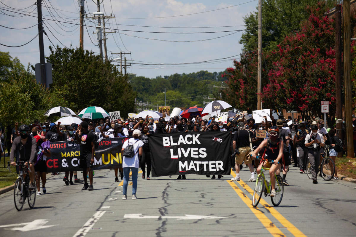 People march behind a Black Lives Matter banner during a street protest