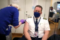 United Airlines pilot Steve Lindland receives a COVID-19 vaccine from RN Sandra Manella at United's onsite clinic at O'Hare International Airport on March 09, 2021 in Chicago, Illinois.