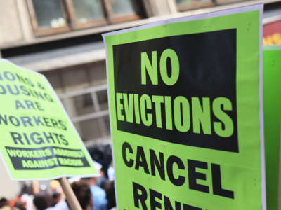 People hold up a signs as they gather outside of a New York City Marshall's office calling for a stop to evictions on August 31, 2021 in New York City.