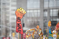 A marcher holds a sign that says "NO WAR" with a closed fist as protest outside of Trump International Tower during the Woman's March in the borough of Manhattan in New York on January 18, 2020.