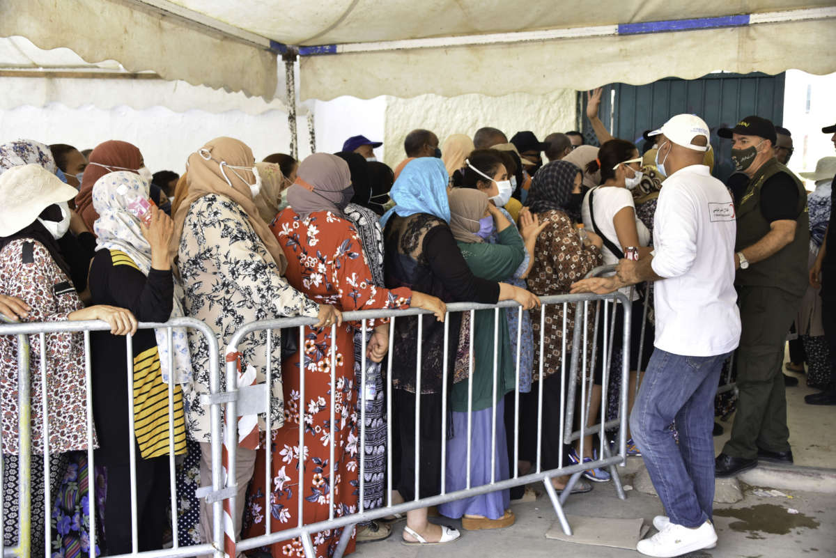 People queue up to receive a COVID-19 vaccine at Oued Ellil high school in Manouba, Tunisia, on August 8, 2021.