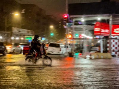 A delivery worker makes their way in the rainfall from Hurricane Ida during a flood on Intervale Avenue on September 1, 2021, in the Bronx borough of New York City.