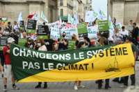 Protesters hold a banner reading "Change the system not the climate" while demanding action against climate change on the sidelines of the International Union for Conservation of Nature (IUCN) congress in Marseille, France, on September 3, 2021.