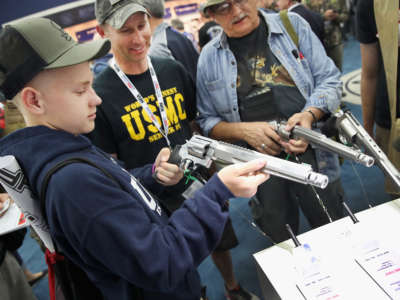 A young gun enthusiast looks over a Smith & Wesson pistol at the National Rifle Association's Annual Meeting & Exhibits on May 21, 2016, in Louisville, Kentucky.