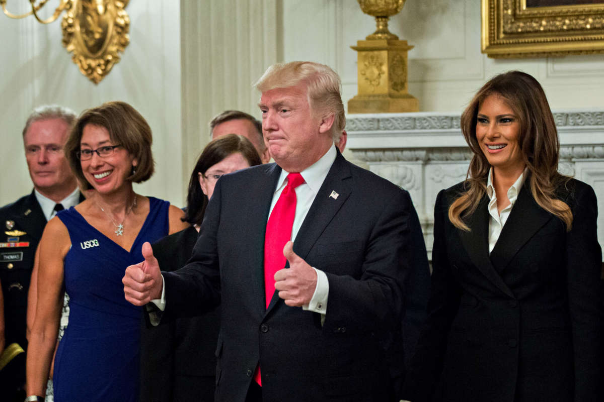 President Donald Trump and first lady Melania Trump pose for pictures with senior military leaders and spouses after a briefing in the State Dining Room of the White House on October 5, 2017, in Washington, D.C.