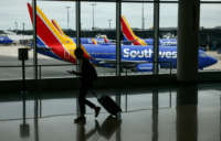 A traveler walks past a Southwest Airlines airplane as it taxies from a gate at Baltimore Washington International Thurgood Marshall Airport on October 11, 2021, in Baltimore, Maryland.