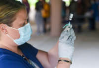 A health care worker with the Berks Community Health Center fills a syringe with a dose of COVID-19 vaccine at the Reading Area Community College campus in Reading, Pennsylvania, on September 14, 2021.
