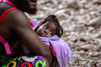 A Haitian baby is held by her dad