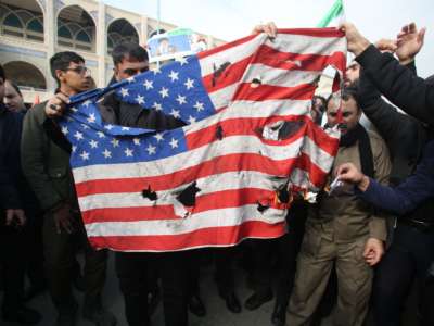 Iranians burn a U.S. flag during a demonstration against American "crimes" in Tehran on January 3, 2020, following the assassination of Iranian Revolutionary Guards Major General Qassim Suleimani in a U.S. strike on his convoy at Baghdad international airport.